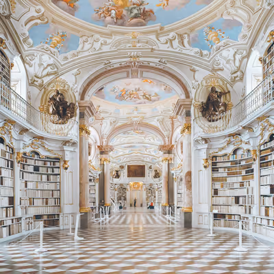 Grand library with marble pillars, gold details, and fresco ceiling